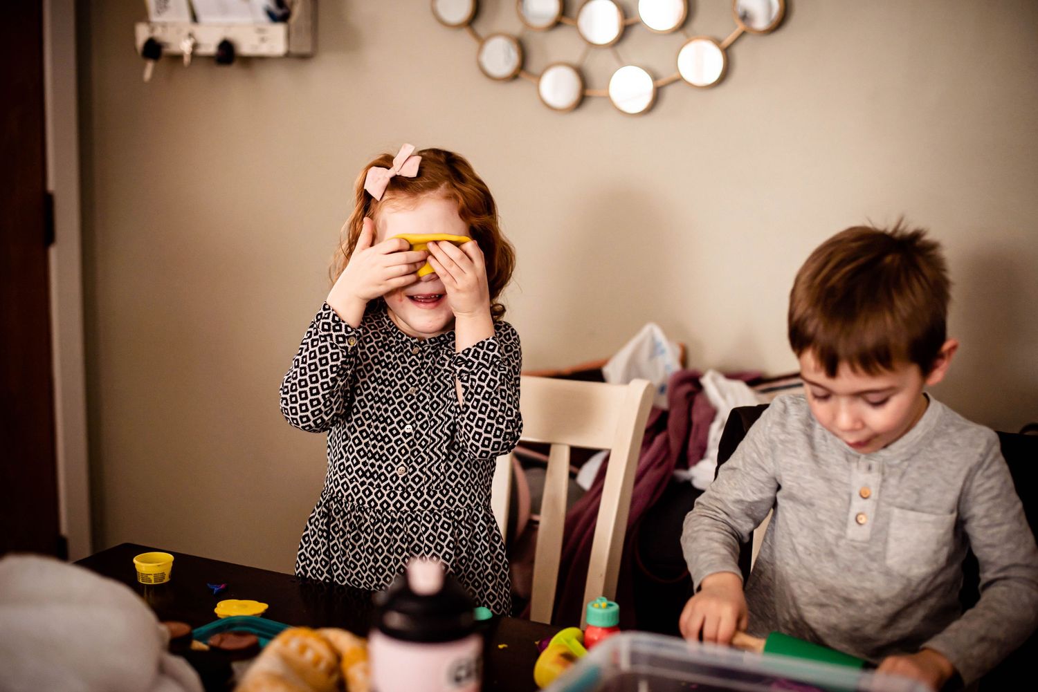 Two children playing together at a table with toys and activities.