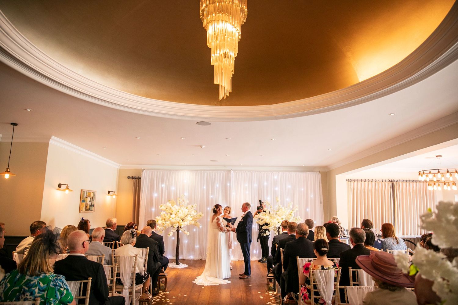 Elegant ballroom reception venue with warm lighting and crystal chandeliers.