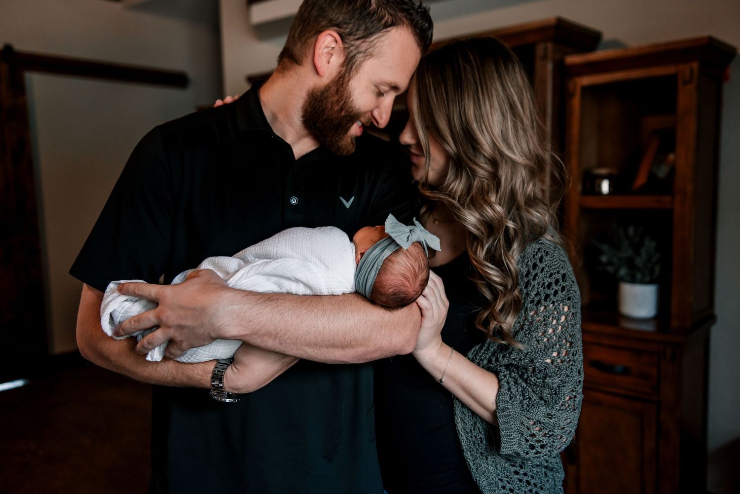 Intimate family moment captured in warm, dimly lit room setting.