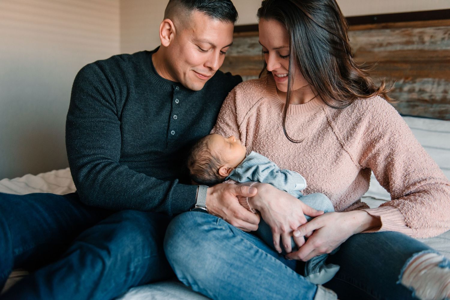 Intimate indoor family moments captured on a couch in soft natural light.