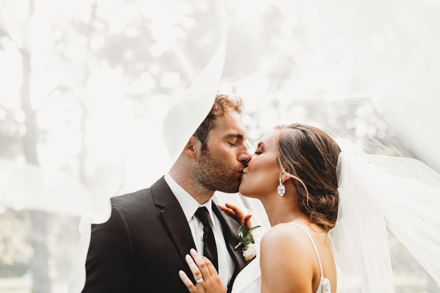 Romantic wedding kiss captured in soft, dreamy lighting.