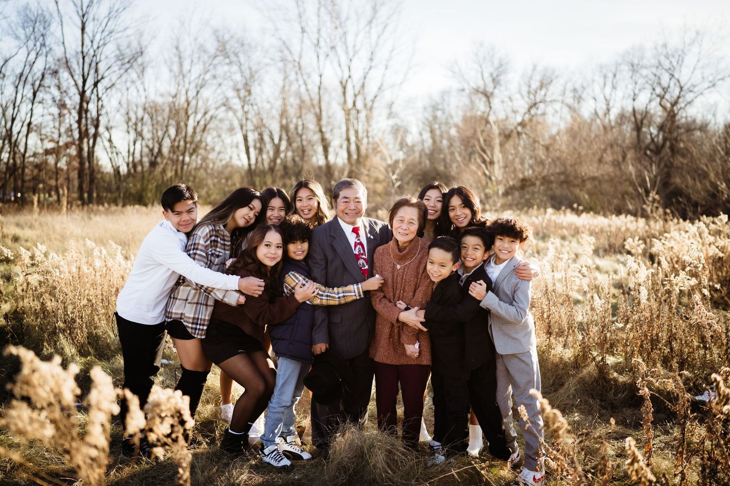 Candid group photo of people hugging and laughing together in a natural outdoor setting.
