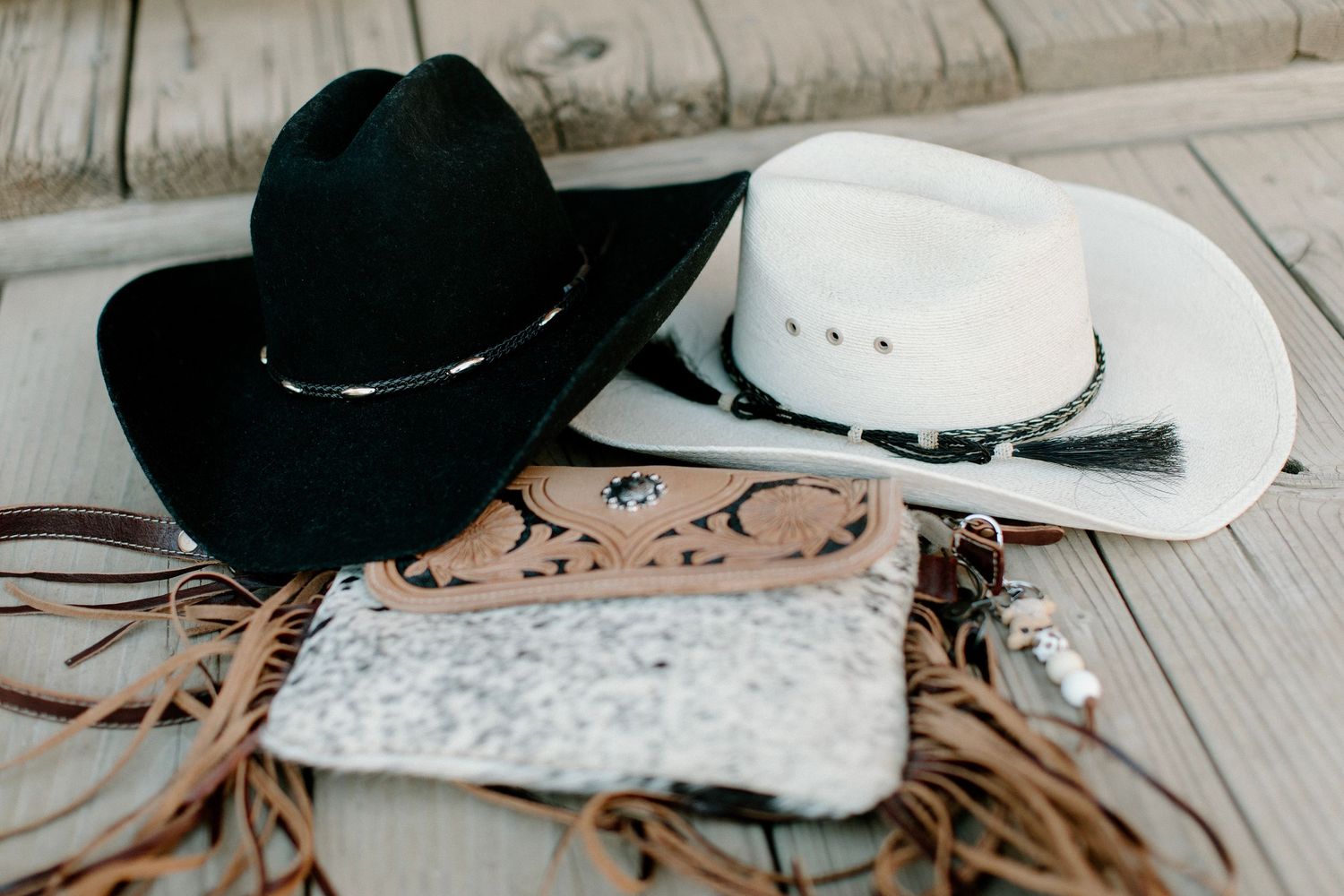 Western style cowboy hats arranged on a rustic wooden surface.