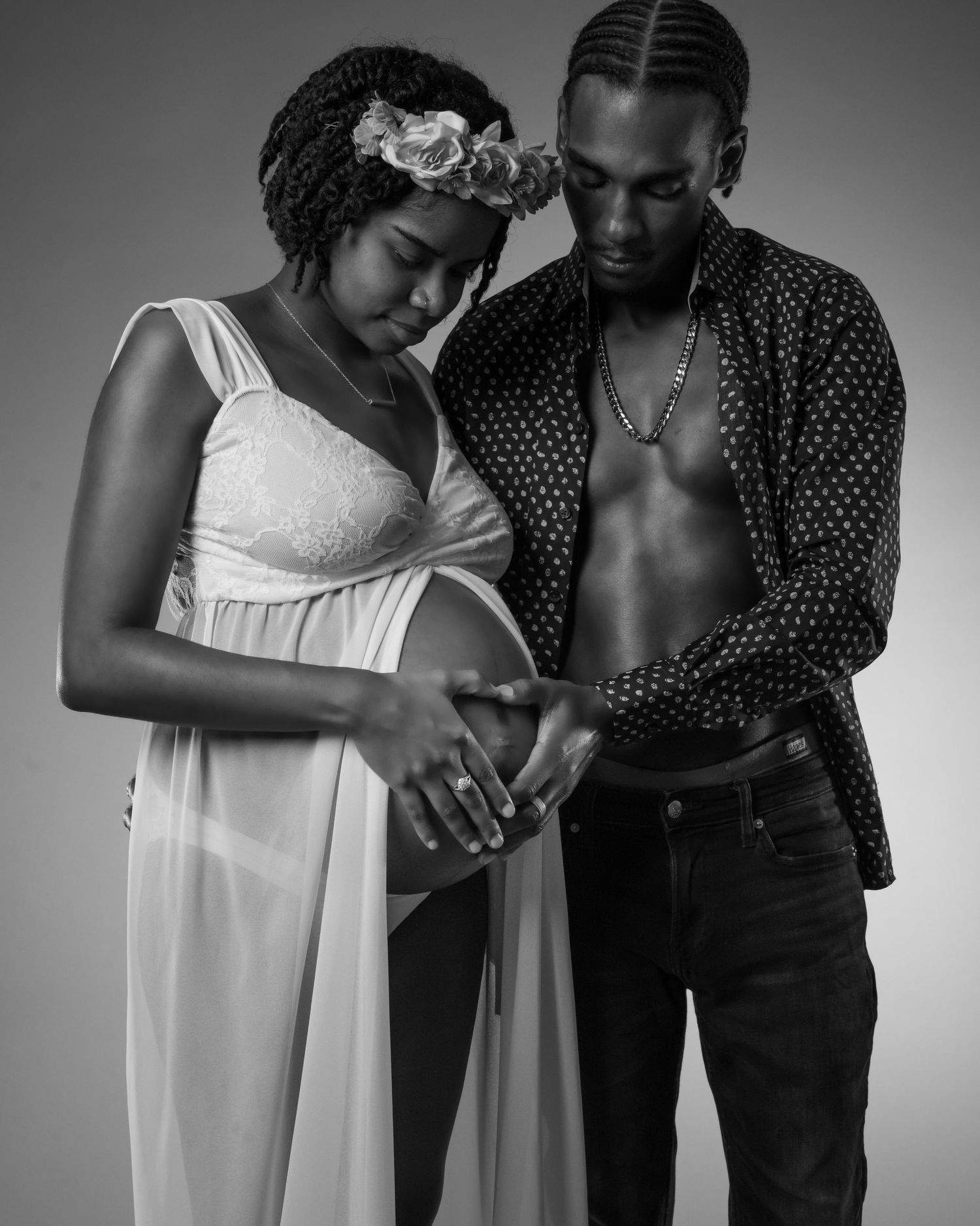Artistic black and white maternity photo of couple in intimate embrace.
