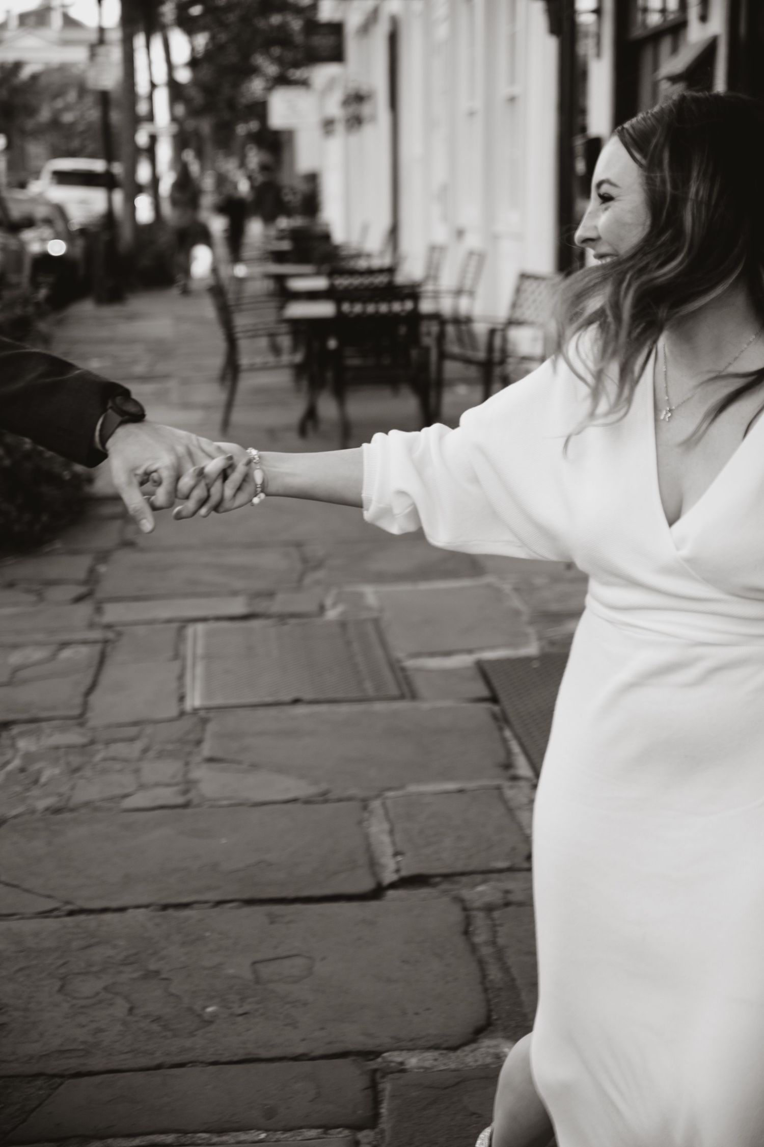 A woman pulls the hand of a man behind her