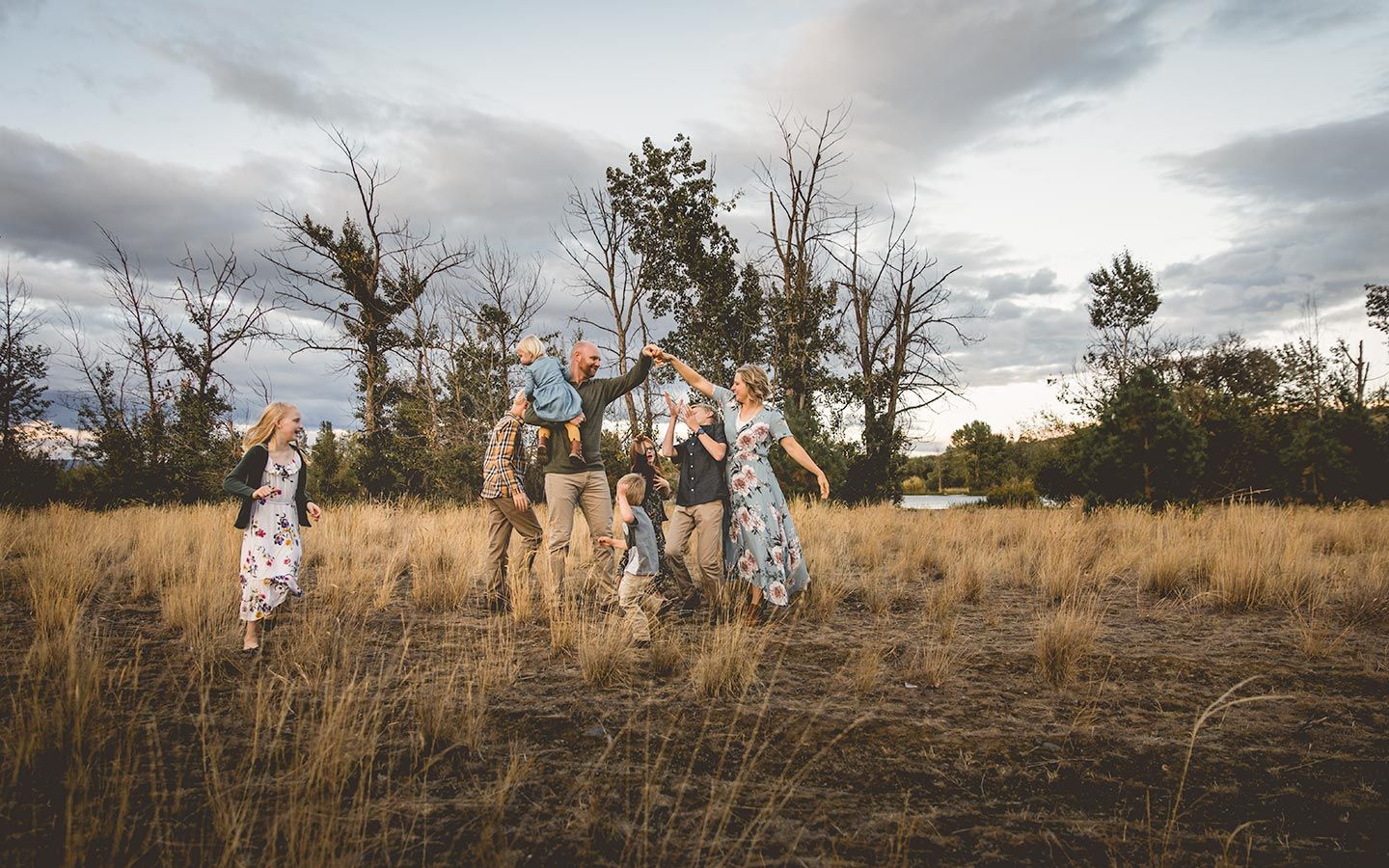 mother and father trying to dance in open field at Helen McCabe State Park while kids run around