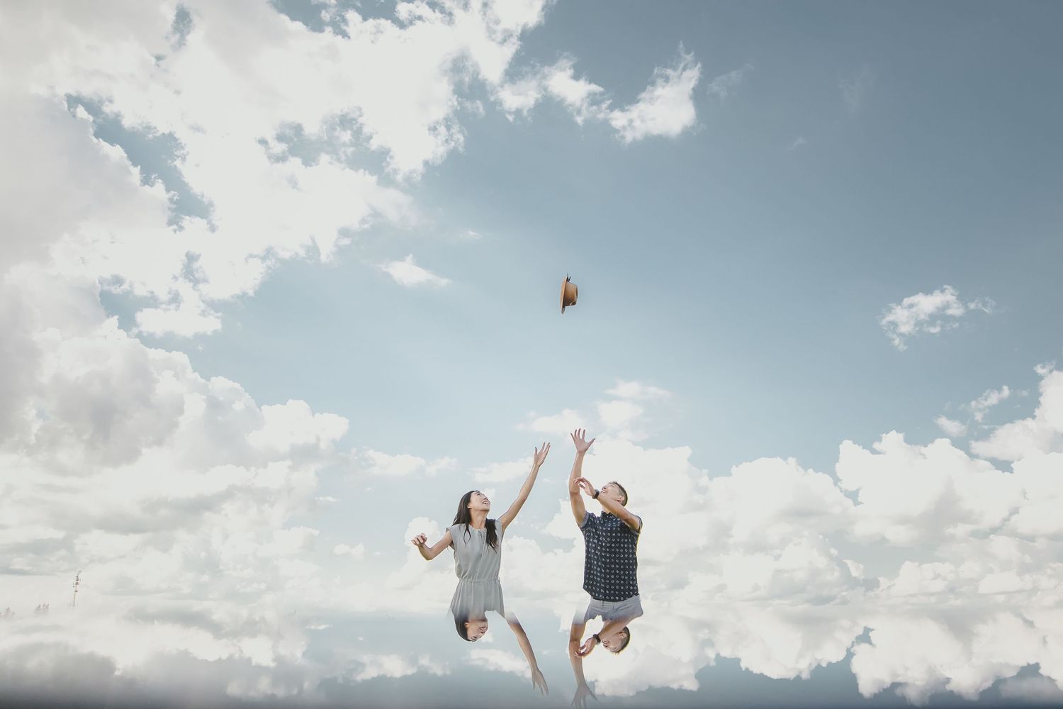 A sequence of silhouetted figures performing backflips against a cloudy blue sky background.