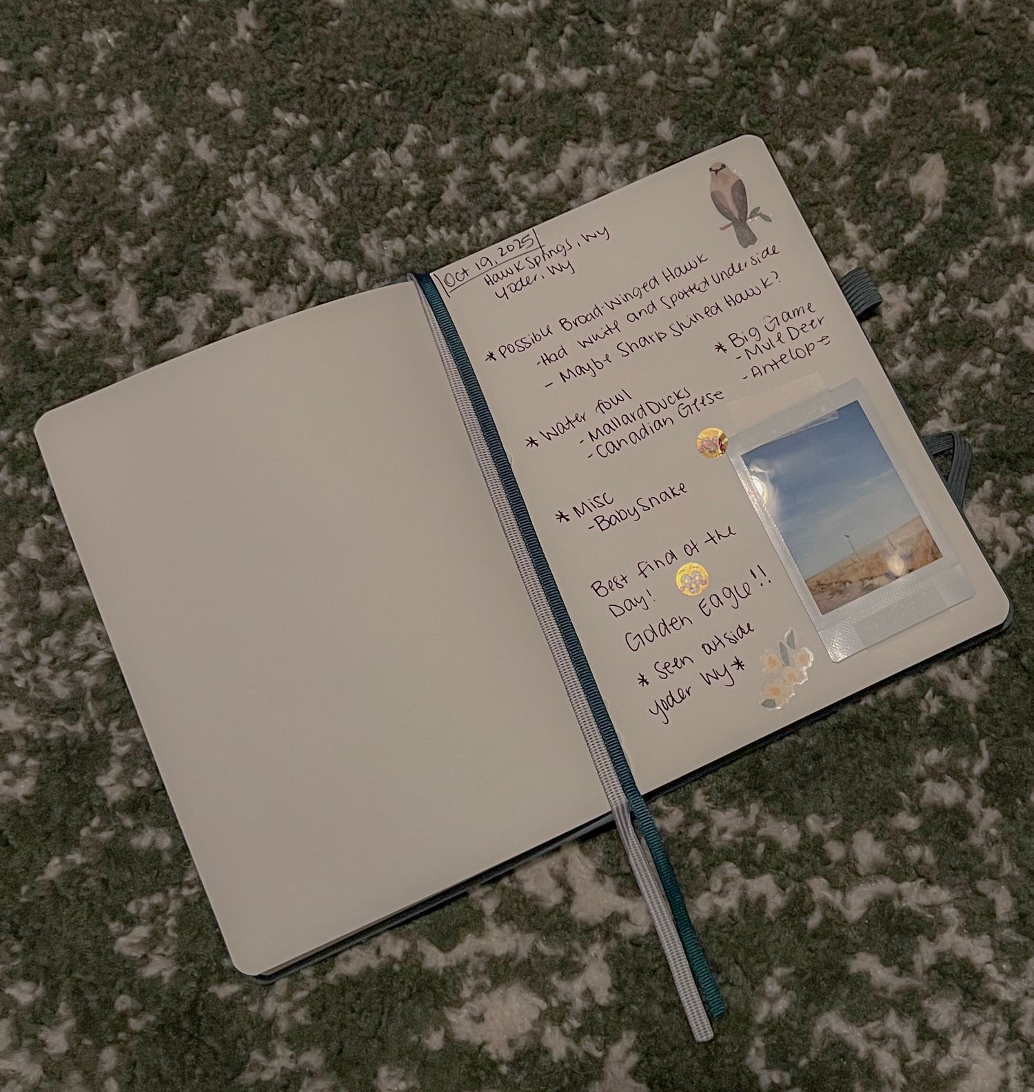 An open journal or planner with handwritten notes and a small photo on a textured surface.