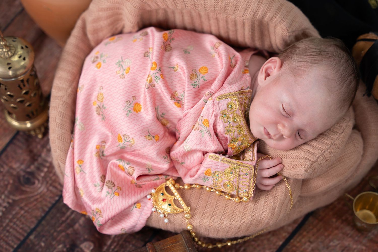 Peaceful newborn baby wrapped in soft fabric during a new born photoshoot Dubai session.