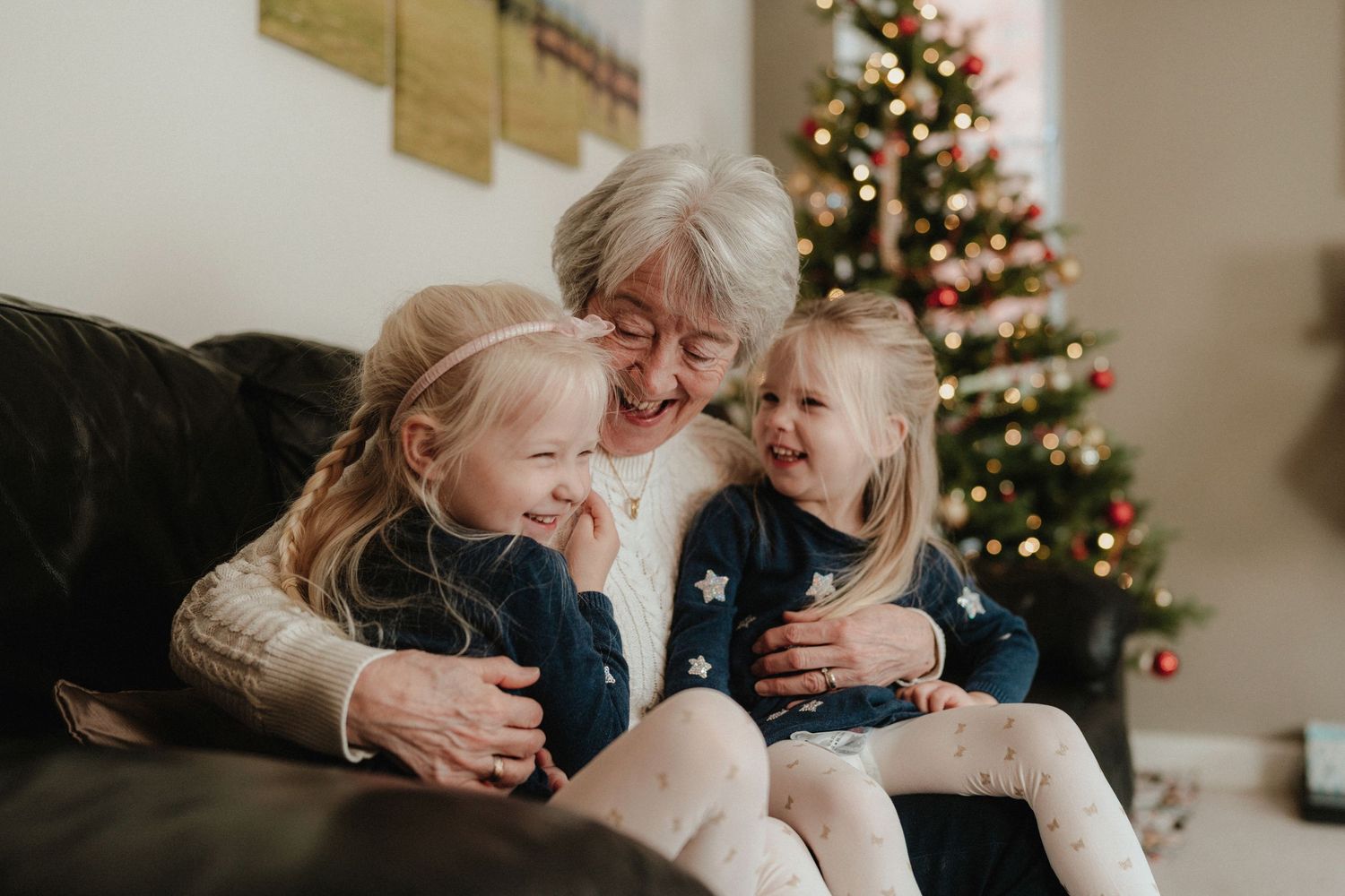 Cozy family moment captured near decorated Christmas tree indoors.