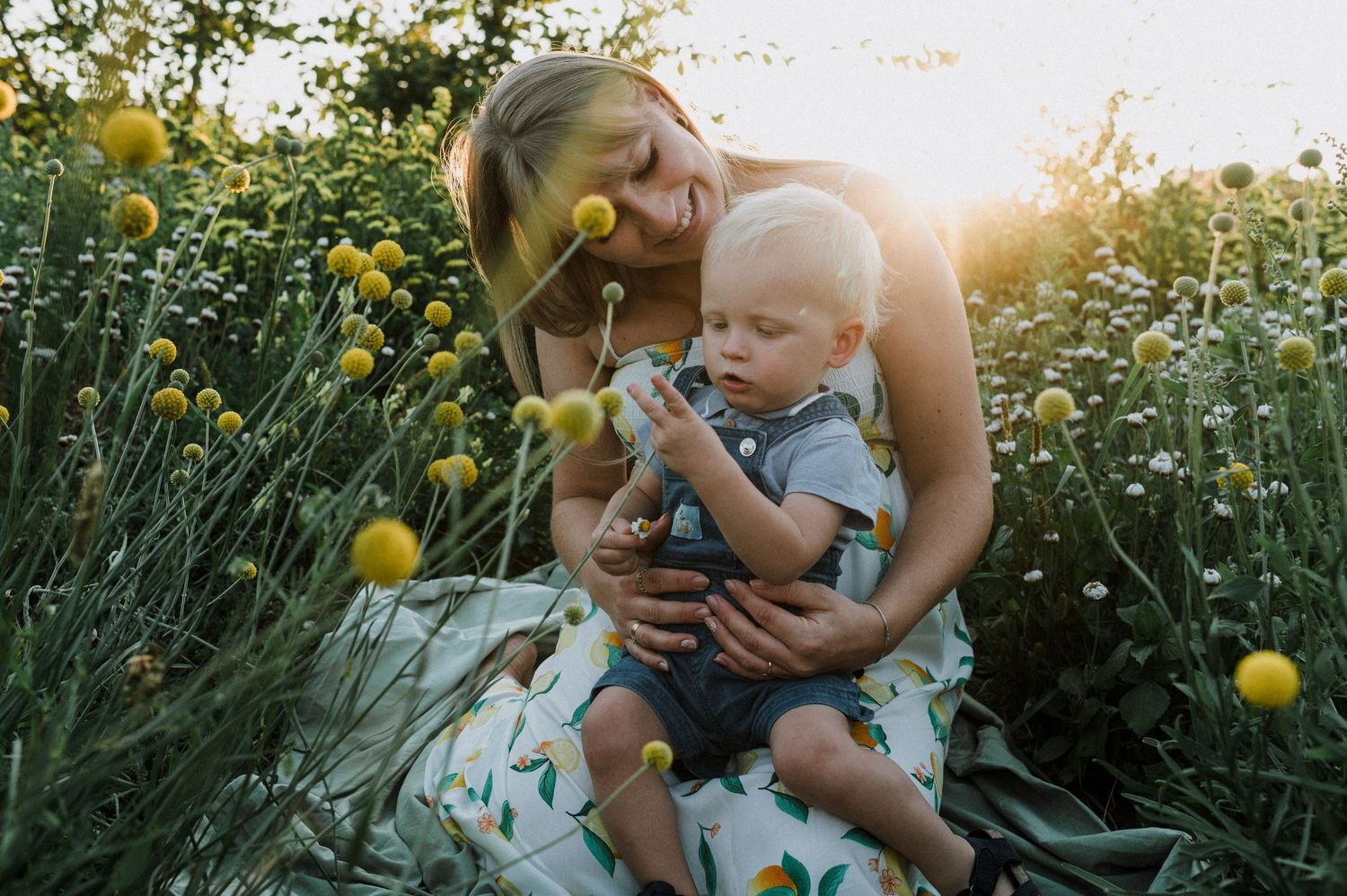 A couple walks through a vibrant field of yellow sunflowers on a sunny summer afternoon.