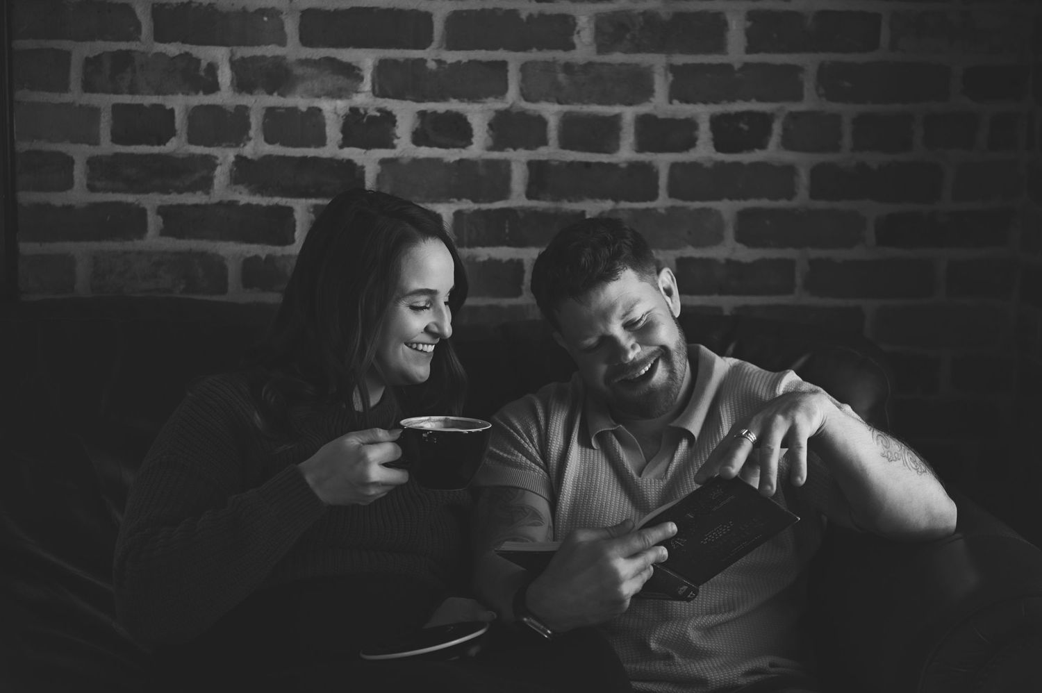 Black and white photograph of a family sharing an intimate moment together by a window at home.