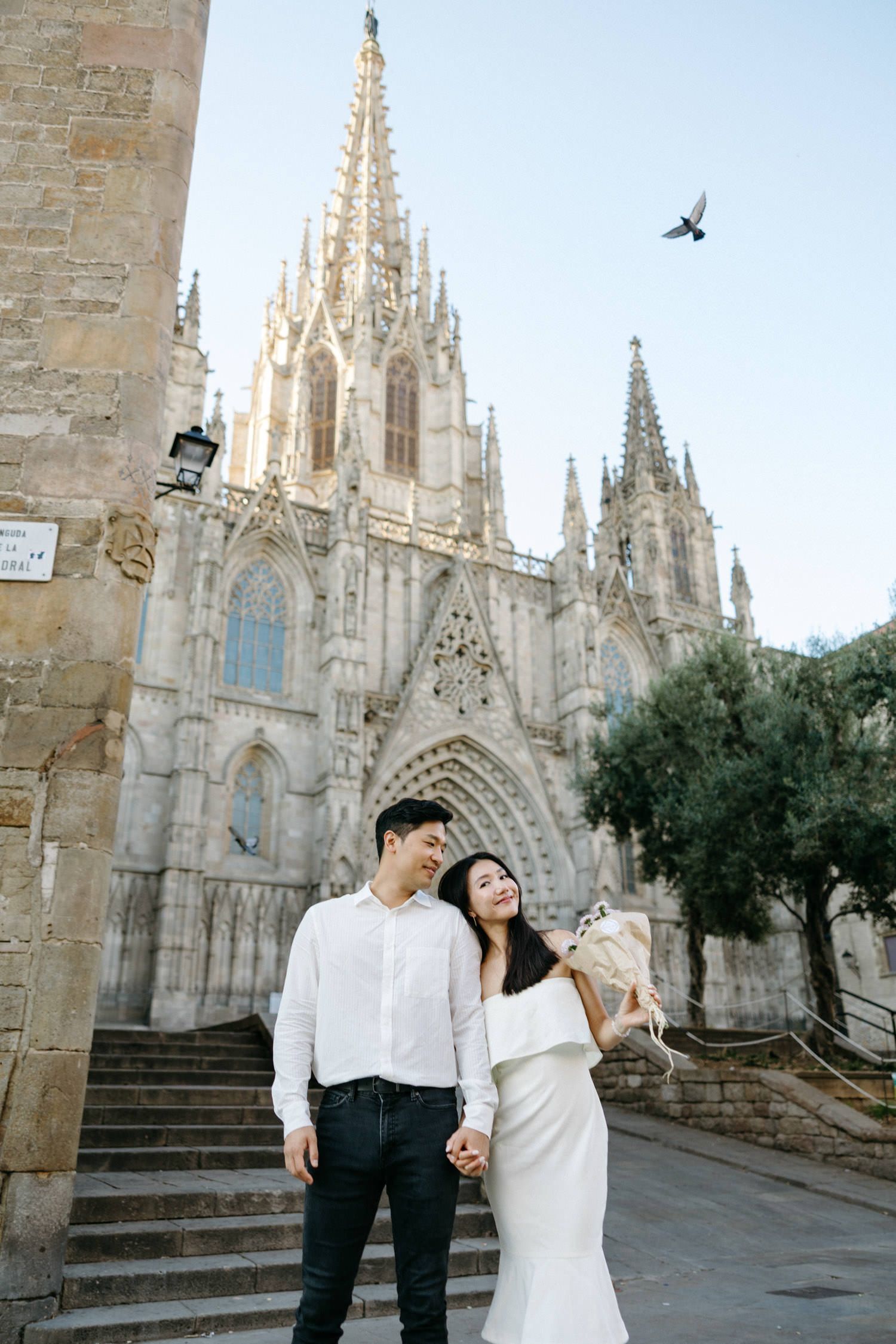 Couple dancing and twirling in front of a Gothic cathedral with ornate spires.