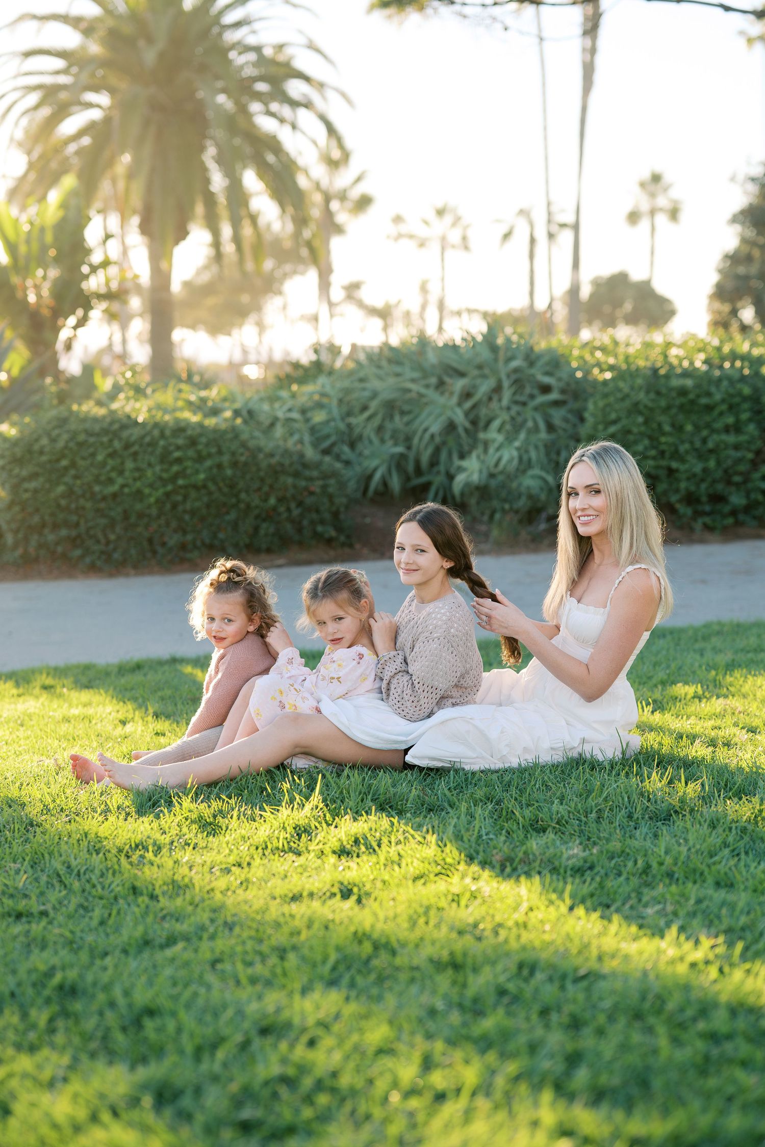 People relaxing together on grass in a park during golden hour sunset.