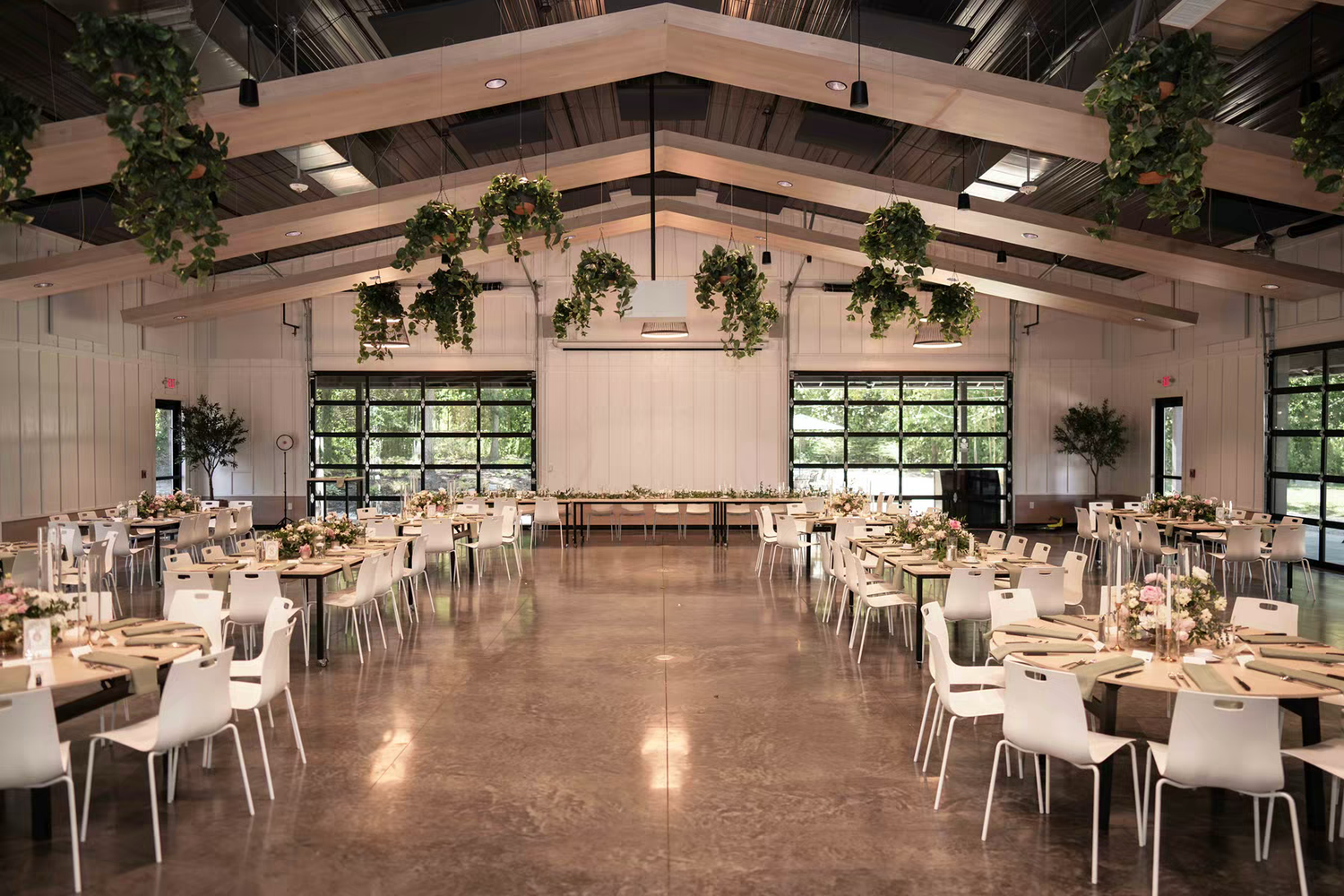 Retreat 21 Wedding Venue Modern interior with white tables, hanging plants, and natural lighting