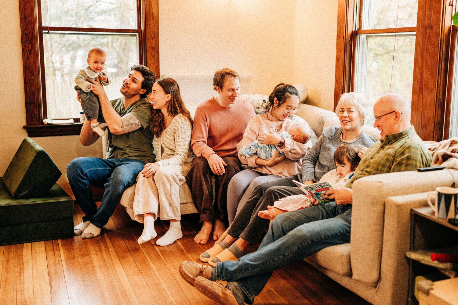 Boston lifestyle family photographer captures large multigenerational family gathering on couch at home in Lexington MA