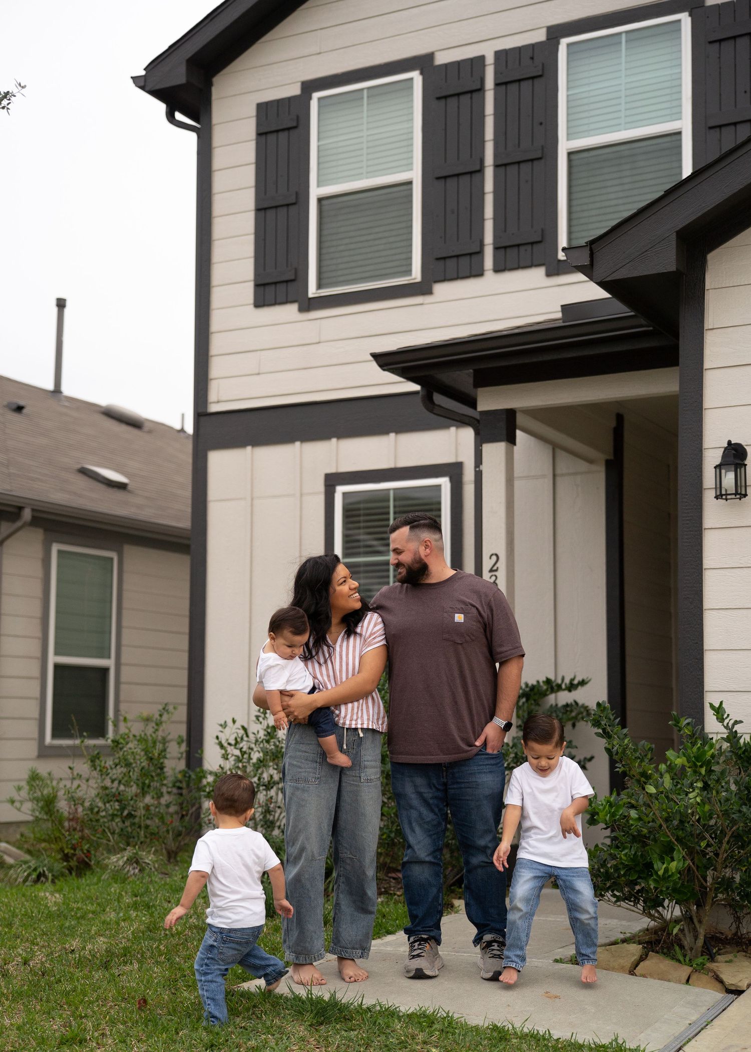 Family portrait in empty home with natural light, showing love and connection as they prepare for a new baby