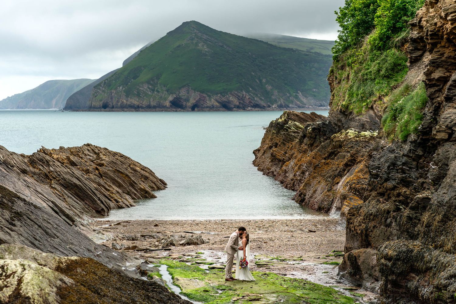 Bride and Groom on the beach kissing at their Watermouth Cove Wedding in North Devon
