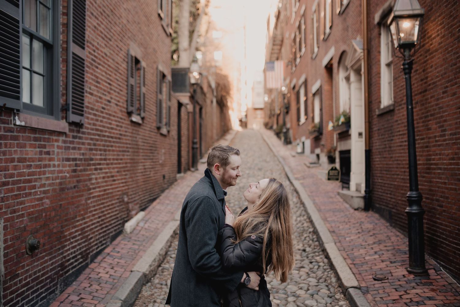 Couple standing on historic Beacon Hill cobblestone street in Boston.