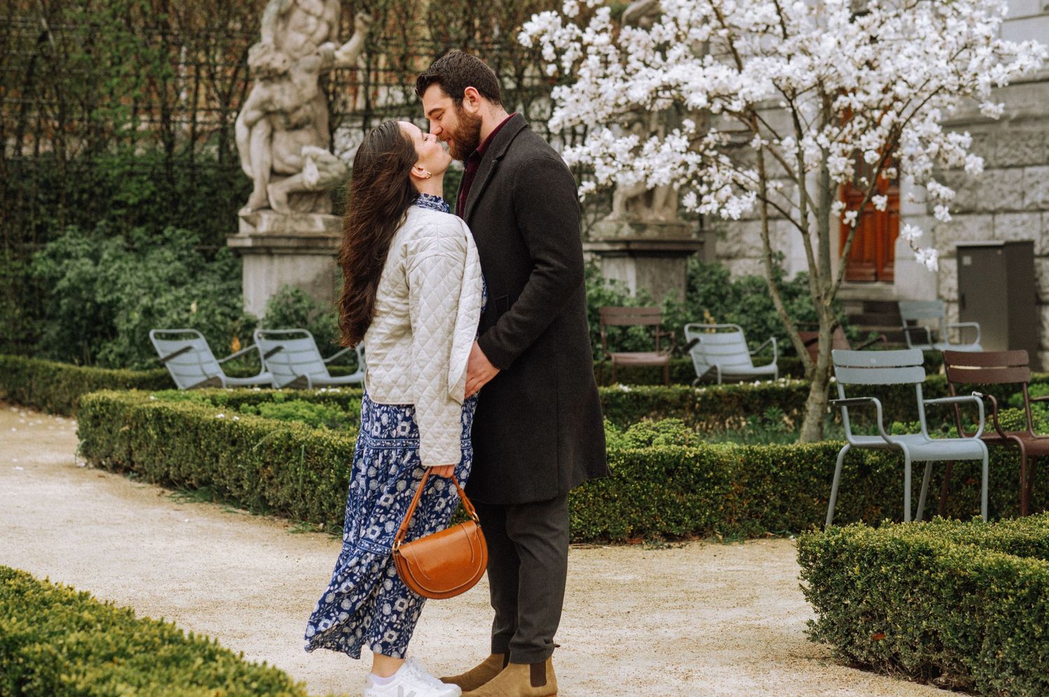 A couple kissing in the Rijksmuseum Gardens, Amsterdam. Professional secret proposal photoshoot.