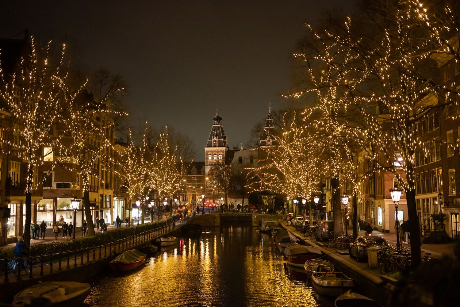 Illuminated canal houses and bridges create a magical nighttime scene in Amsterdam.