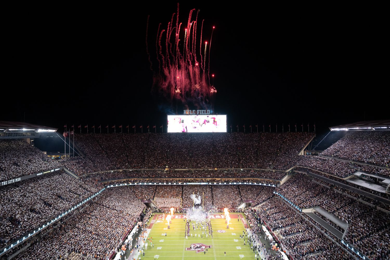 Fireworks illuminate the night sky over a packed college football stadium during a game at Bryant-Denny Stadium.
