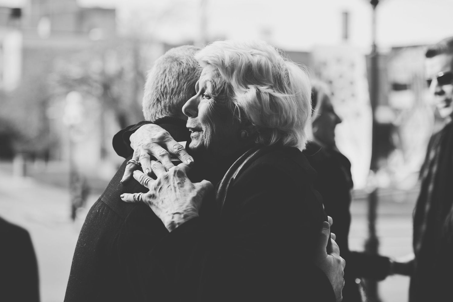 Black and white photo of two people embracing in a hug.