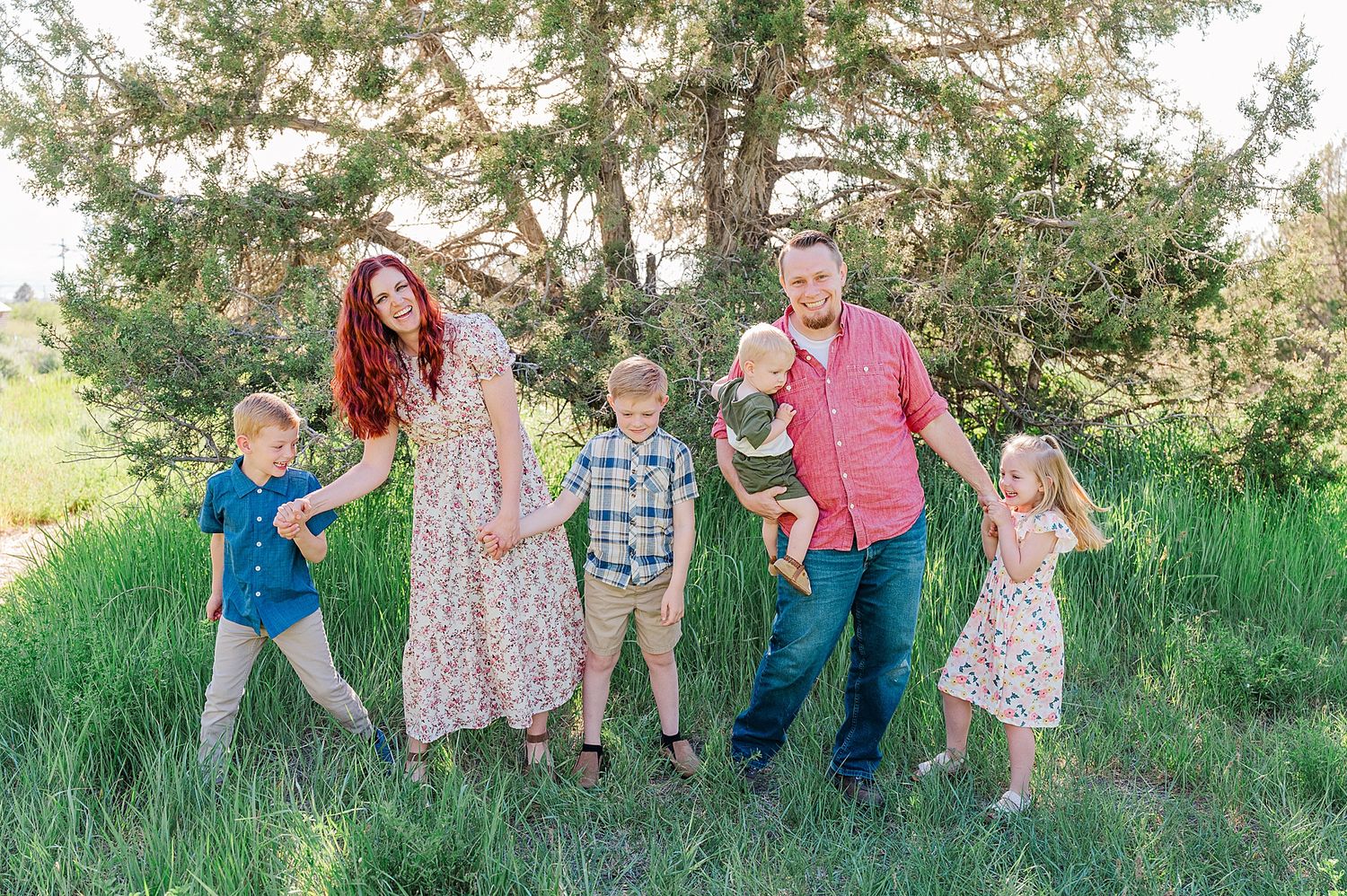 Family in coordinated outfits enjoying time together in a natural outdoor setting.