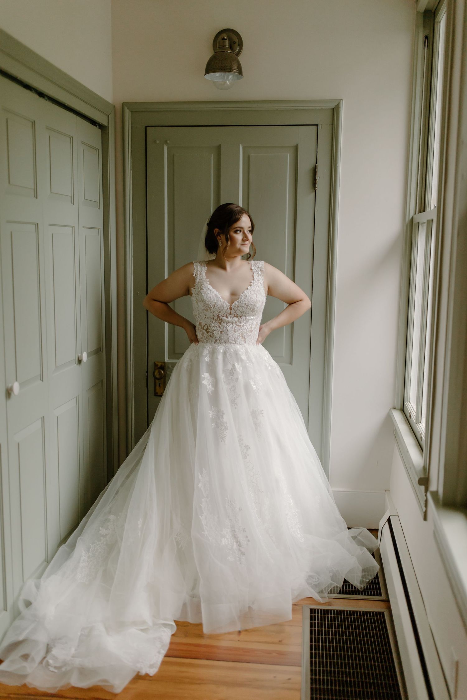 A stunning wedding dress with lace details and tulle skirt photographed in natural window light.