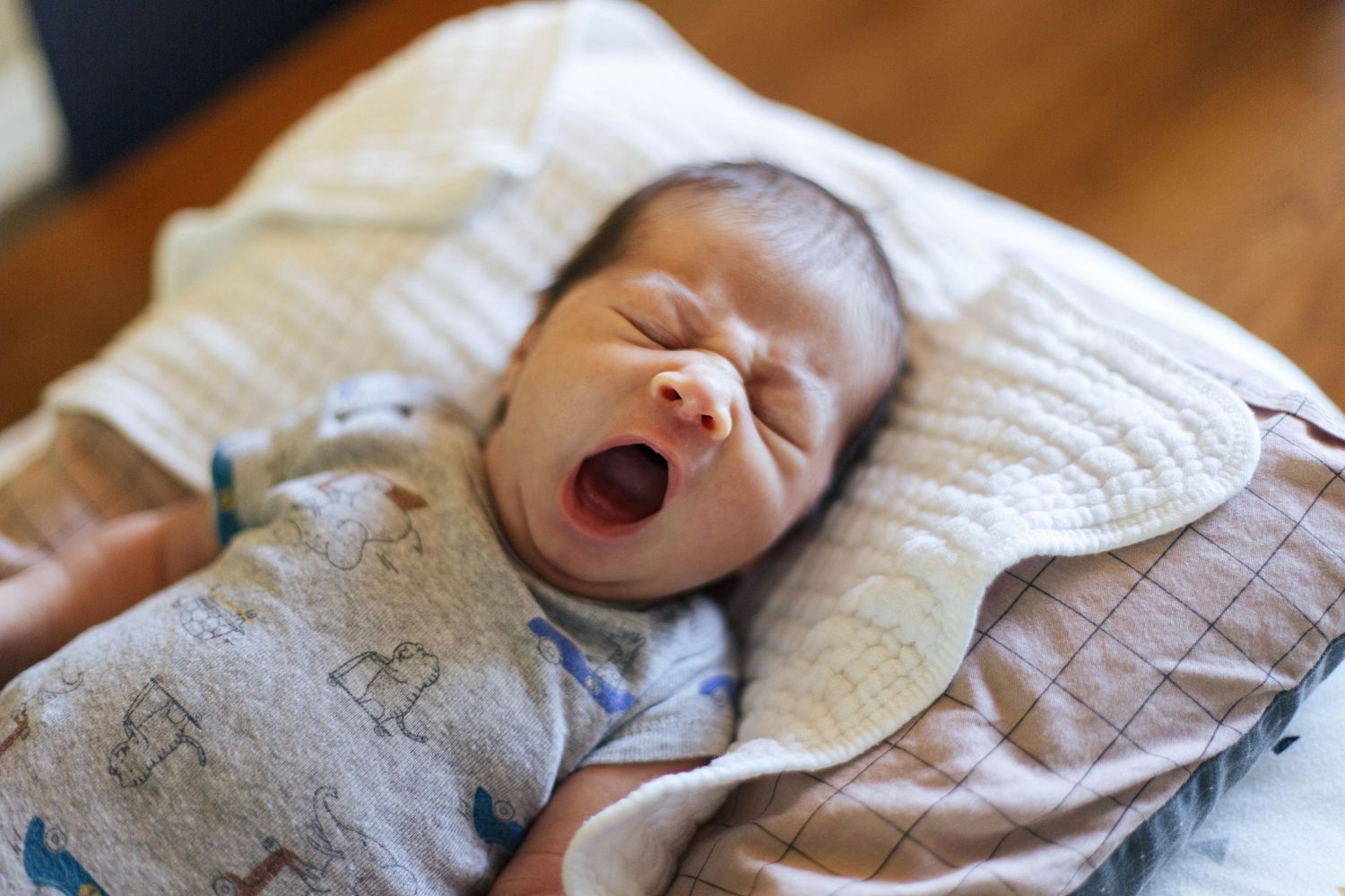 Seattle-Everett newborn photography: a newborn baby yawns at an in-home newborn photo session
