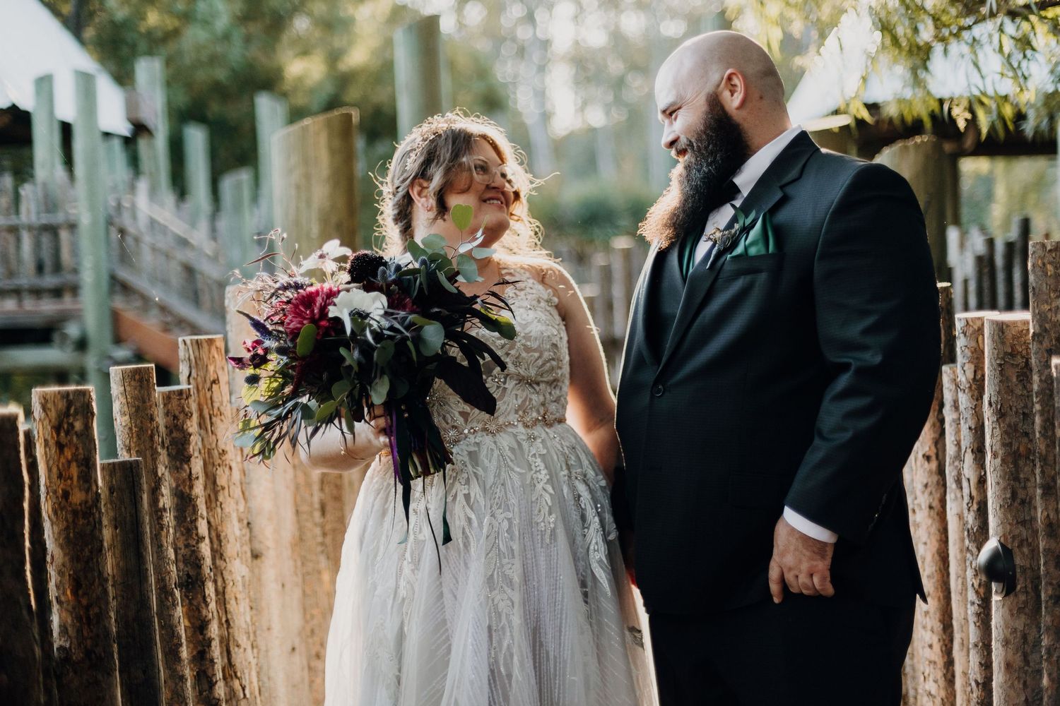 Wedding ceremony participants arranged for photos in a rustic outdoor setting.
