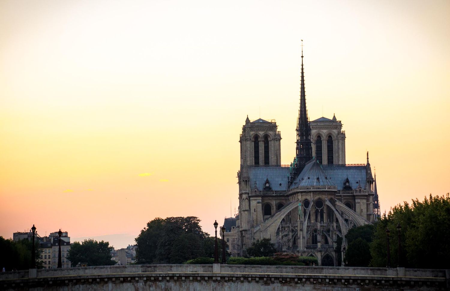 Photo of the Notre Dame Cathedral with the sun setting in the background.