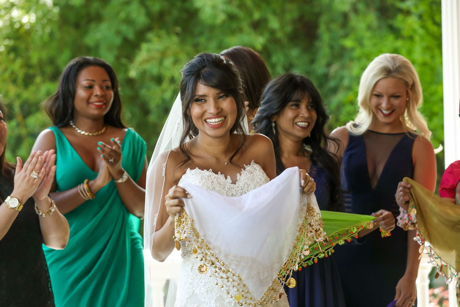 Wedding celebration with bridesmaids in colorful dresses on a sunny outdoor patio.