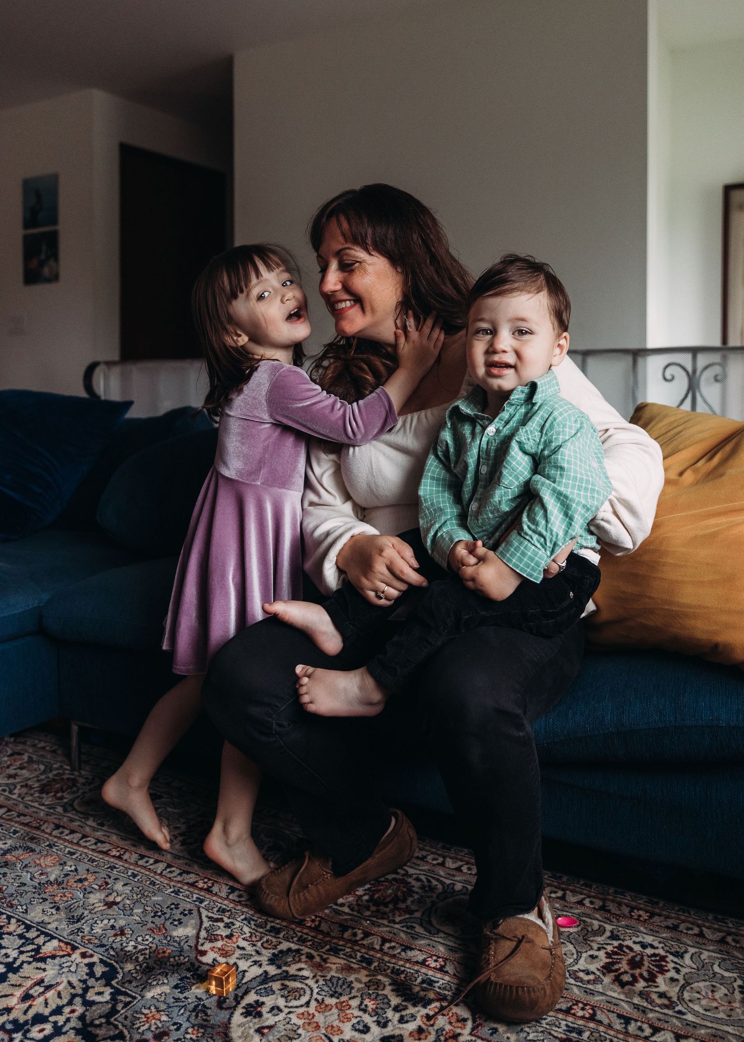 A joyful moment captured on a blue couch with laughter and play in a cozy living room setting.