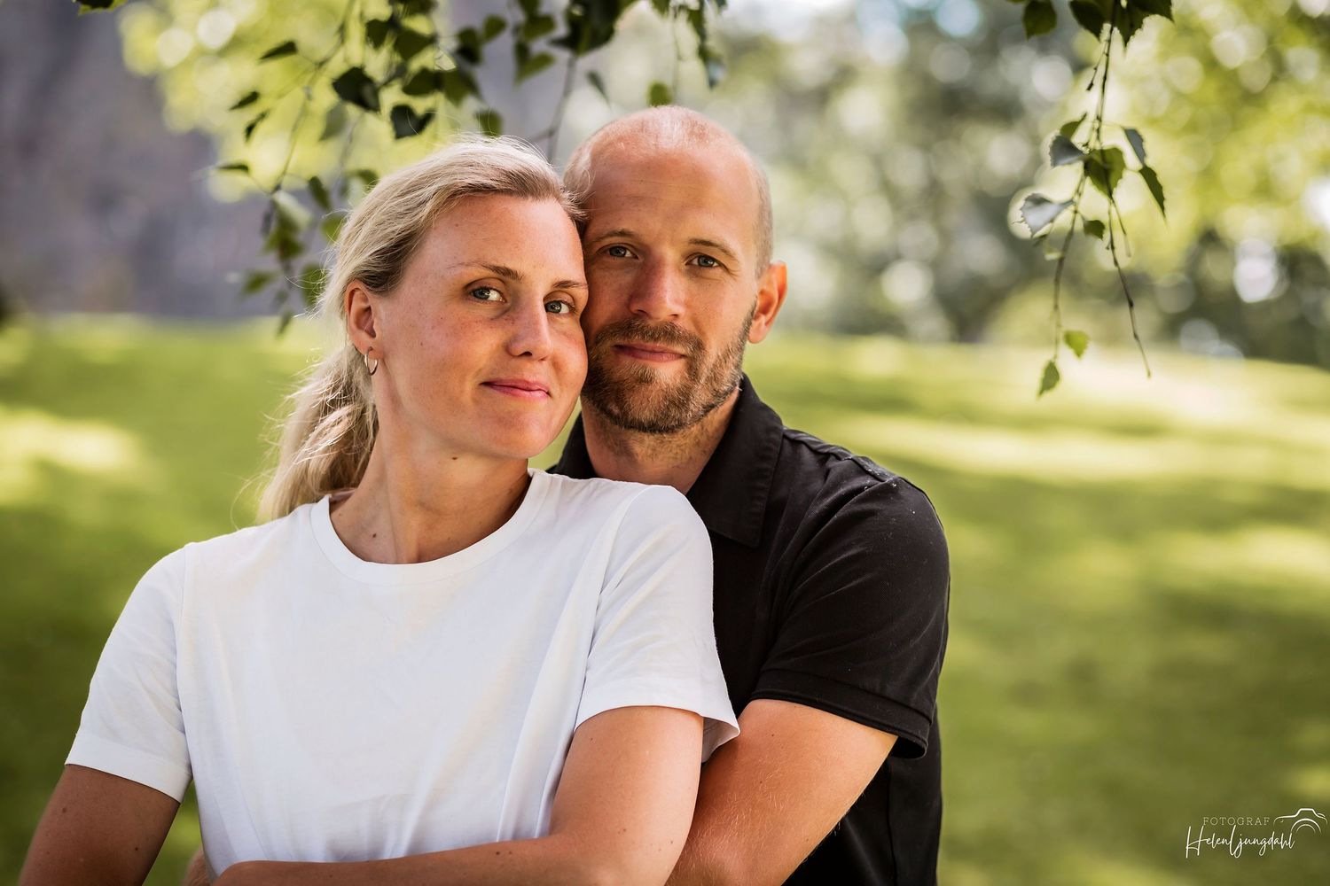 Outdoor portrait of athletic couple standing together in natural sunlight.