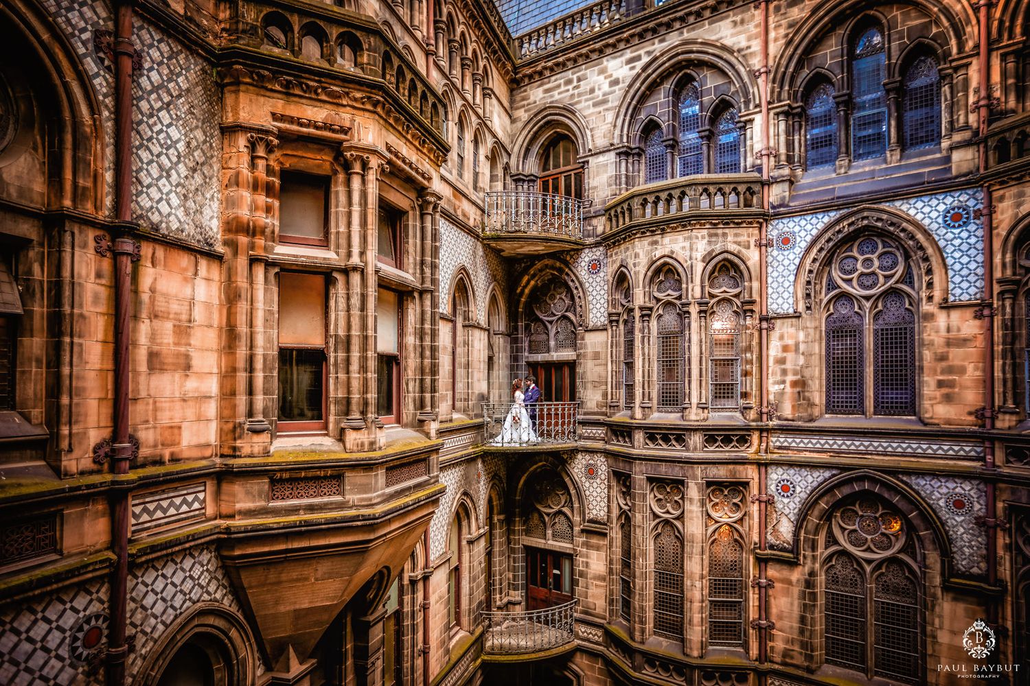 Wedding couple photographed in stunning gothic interior with multiple levels.