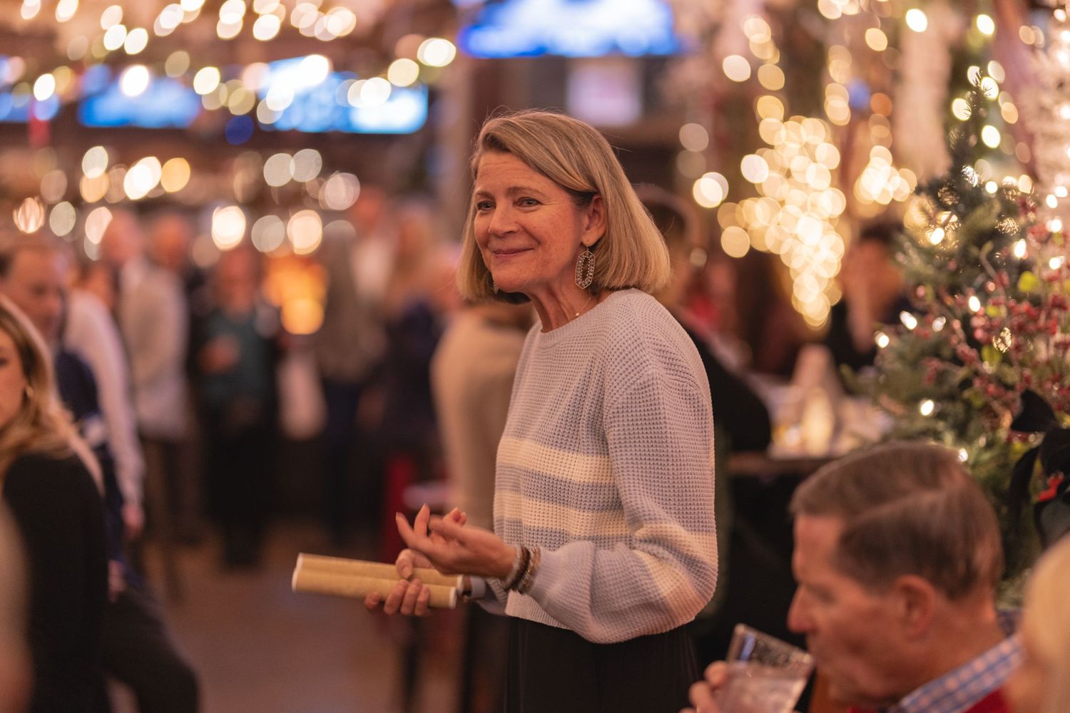 Festive indoor gathering with sparkling holiday lights and decorations creating a warm ambiance.