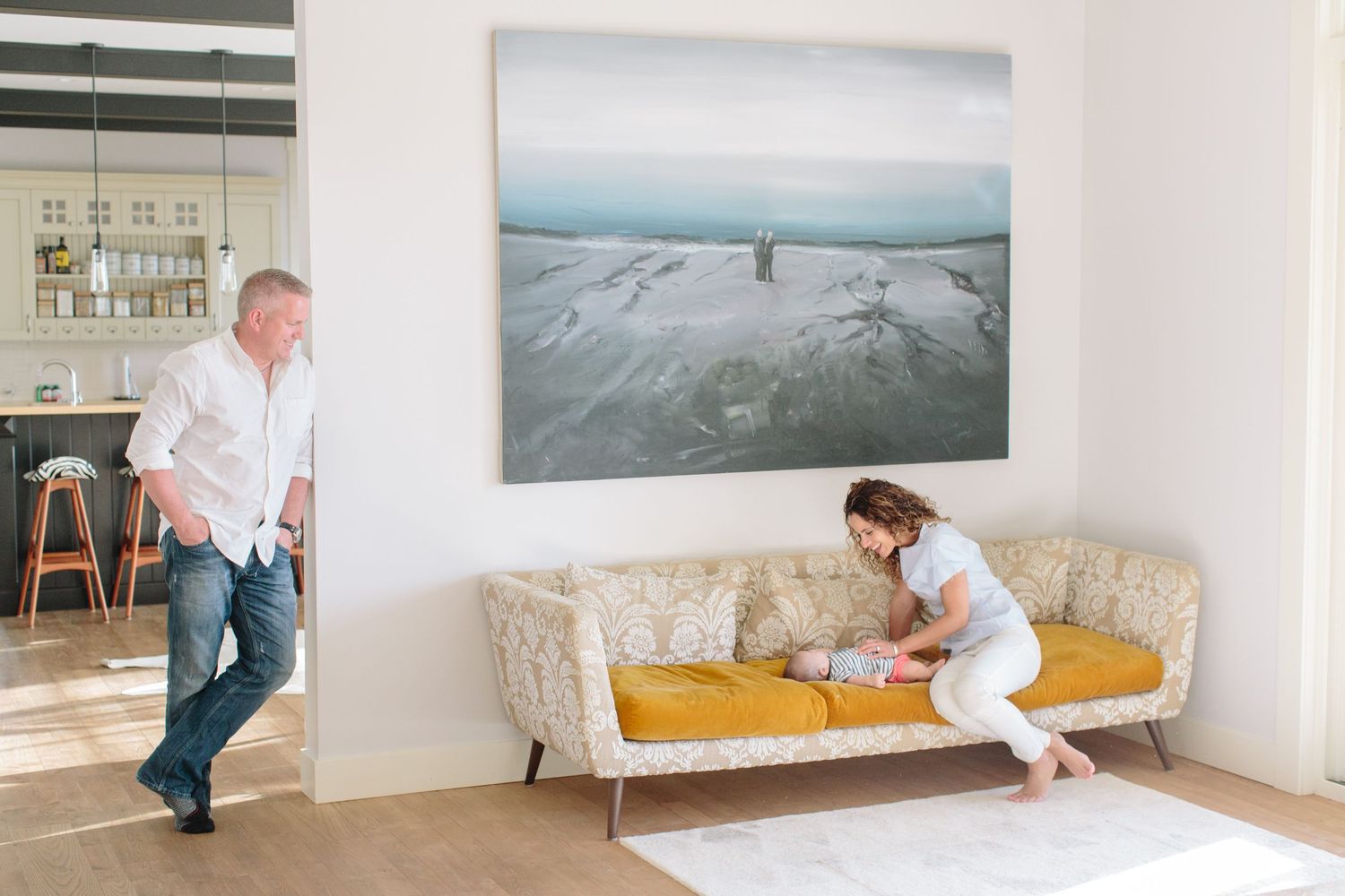 family looking at baby on designer couch