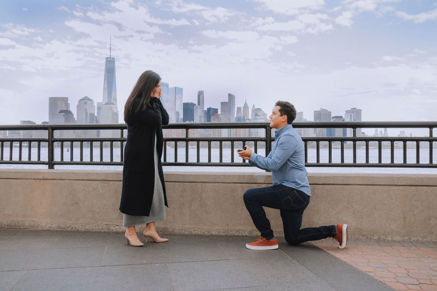A romantic proposal moment with the New York City skyline in the background.