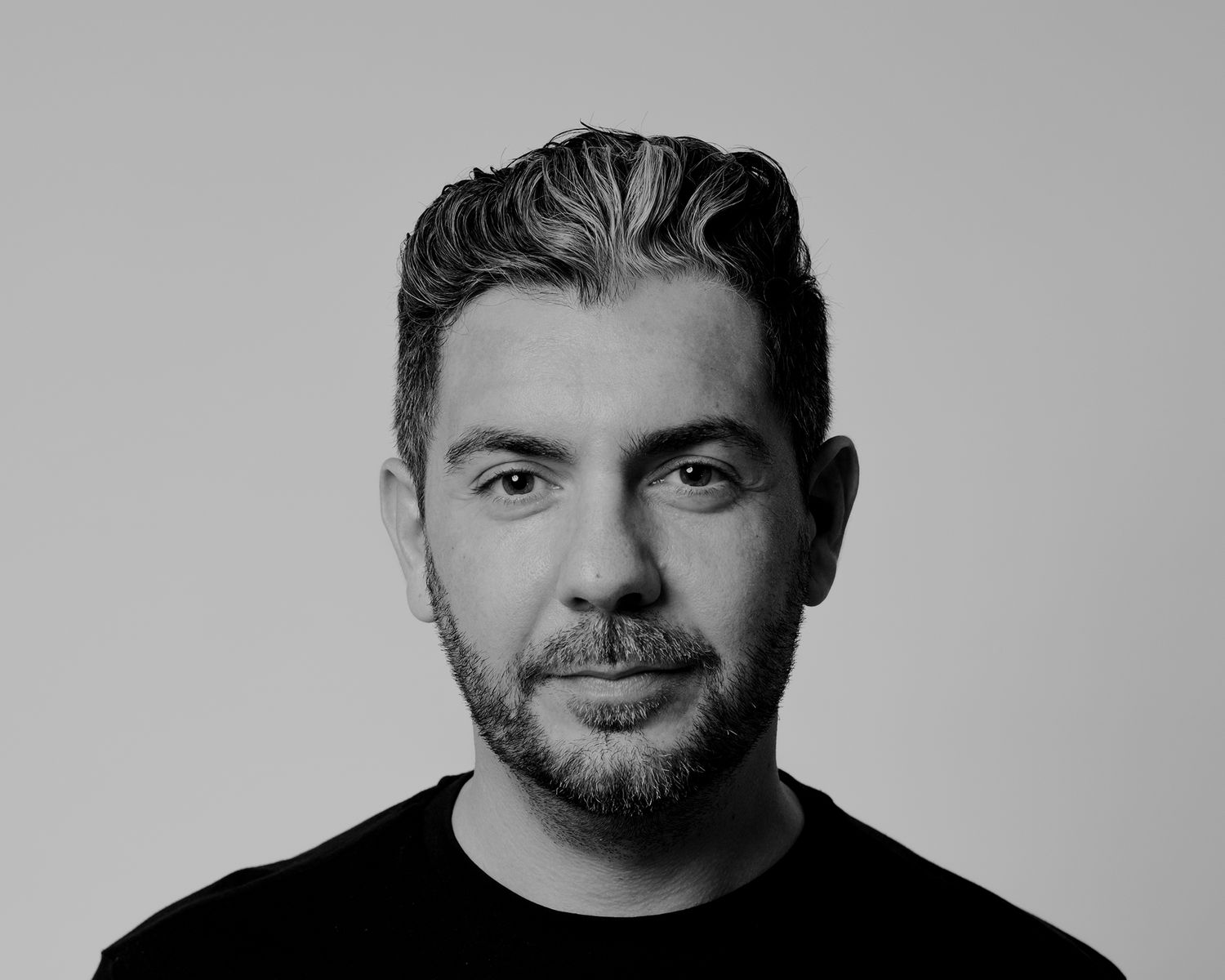 Artistic black and white studio portrait with dramatic lighting.