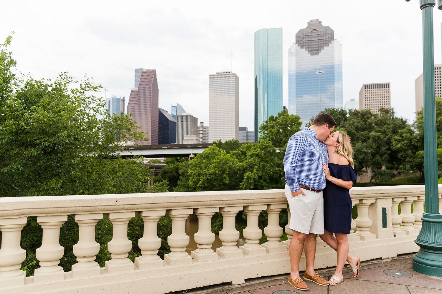 A romantic moment overlooking the Houston skyline from a stone balcony.