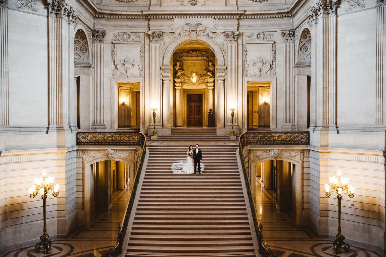 Grand staircase in an ornate classical building with dramatic lighting and architectural details.