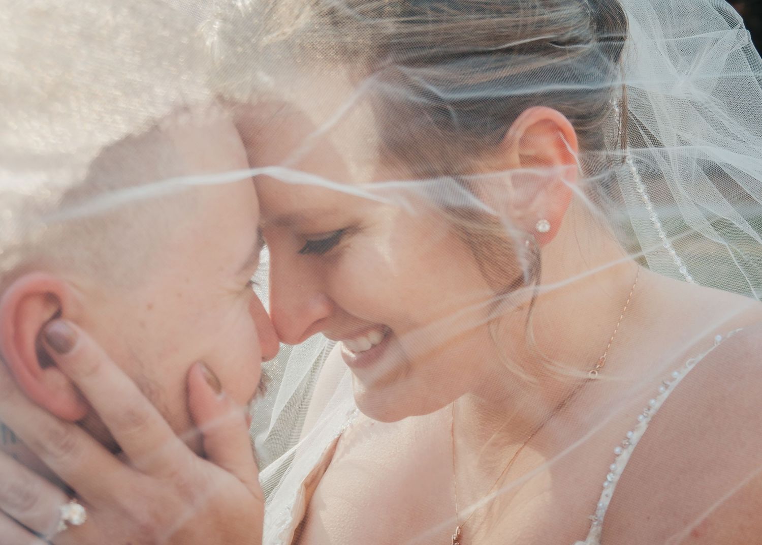 bride and groom under veil
