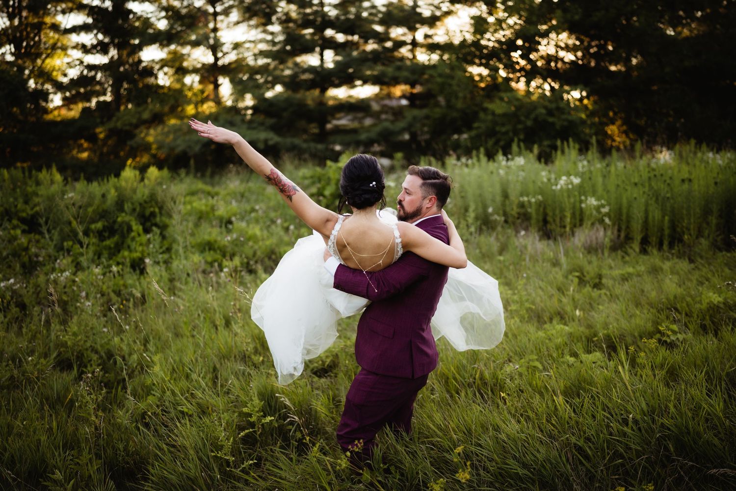 A romantic sunset dance with a couple in purple and white embracing in a grassy meadow.