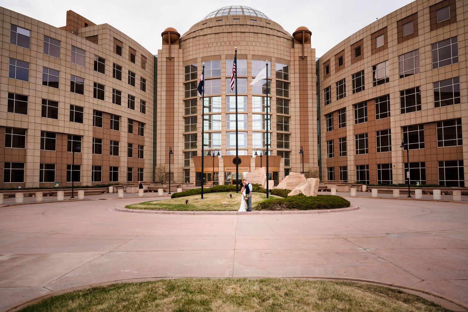 Modern office building exterior with domed glass atrium and symmetrical architecture.
