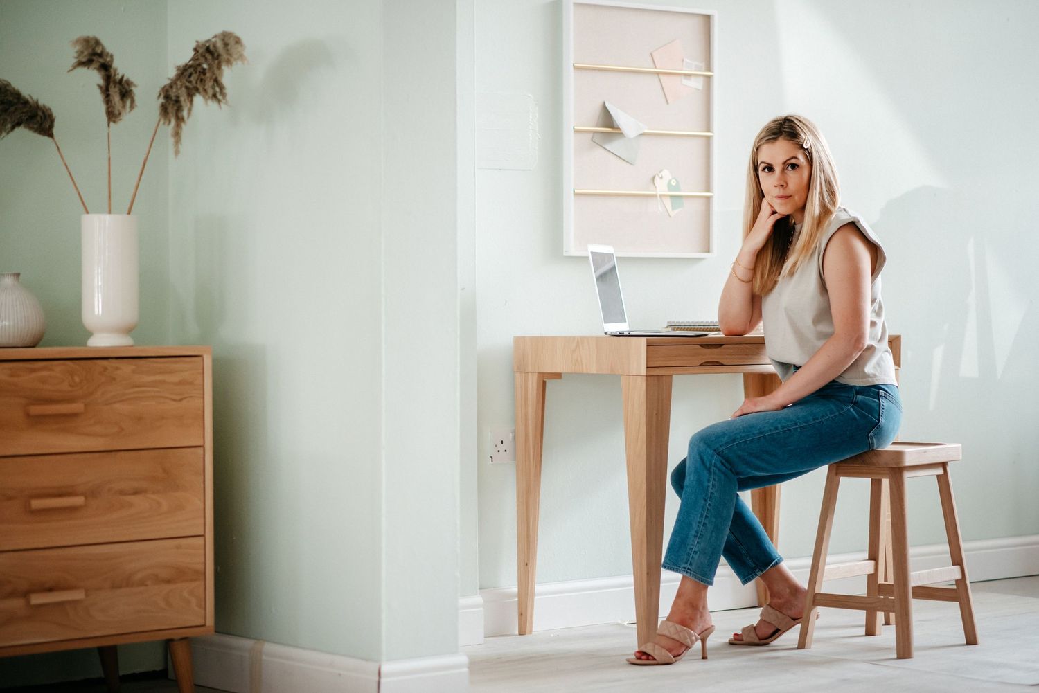 Minimalist home office setup with wooden desk and natural light.