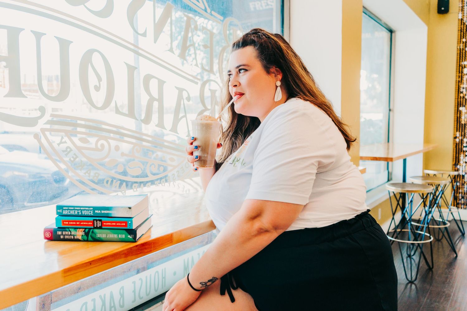 Outdoor Headshot Session in St. Pete, FL; Woman drinking a beverage in a storefront window