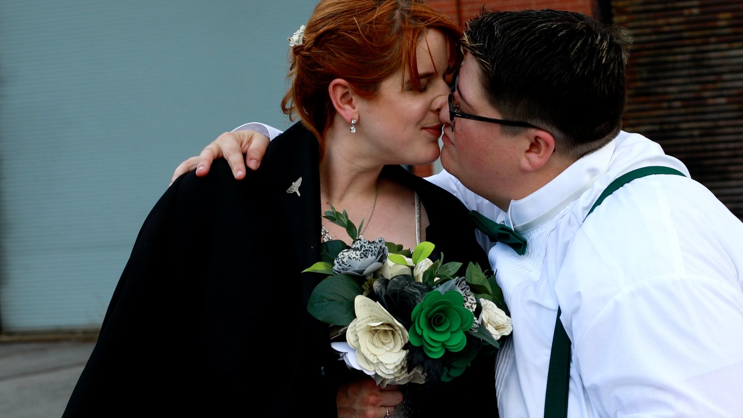 A couple shares an intimate moment with a green and white corsage at their wedding.