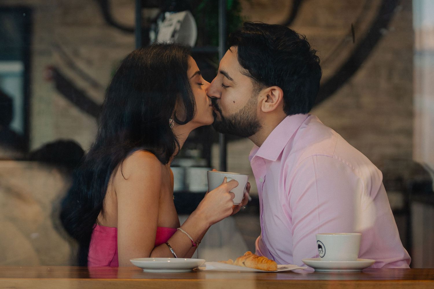 A romantic couple sharing tender moments in a series of intimate photographs at a restaurant setting.