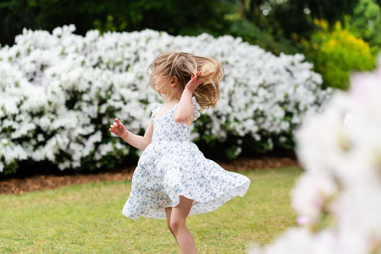 Girl twirling in a Seattle garden.